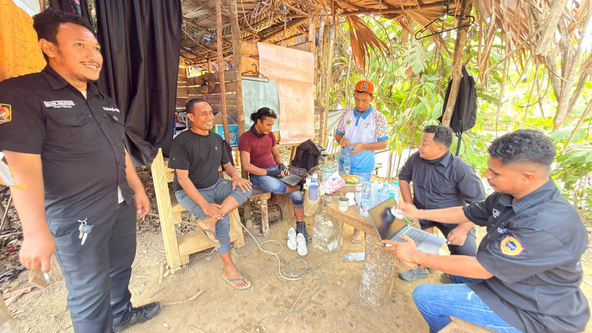 Petugas Bidang Pengelolaan Informasi Administrasi Kependudukan (PIAK) Dukcapil Halmahera Tengah terlihat sibuk mengoperasikan laptop dan peralatan pendukung di pos pelayanan lapangan di KM 30 Akejira. Dalam kegiatan ini, petugas berhasil menyelesaikan perekaman dan penerbitan langsung sejumlah dokumen penting bagi warga Suku Tobelo Dalam (O Hongana Manyawa). Foto: Dok. Dukcapil Halteng
