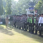 Bupati Halmahera Tengah, Dr. Ir. Ikram Malan Sangadji, M.Si., didampingi salah satu anggota Polri, berjalan melakukan pengecekan barisan personel gabungan TNI, Polri, dan unsur terkait saat memimpin Apel Siaga Pencegahan Karhutla di Mako Polres Halteng, Weda, (3/8/2026). Foto: ist