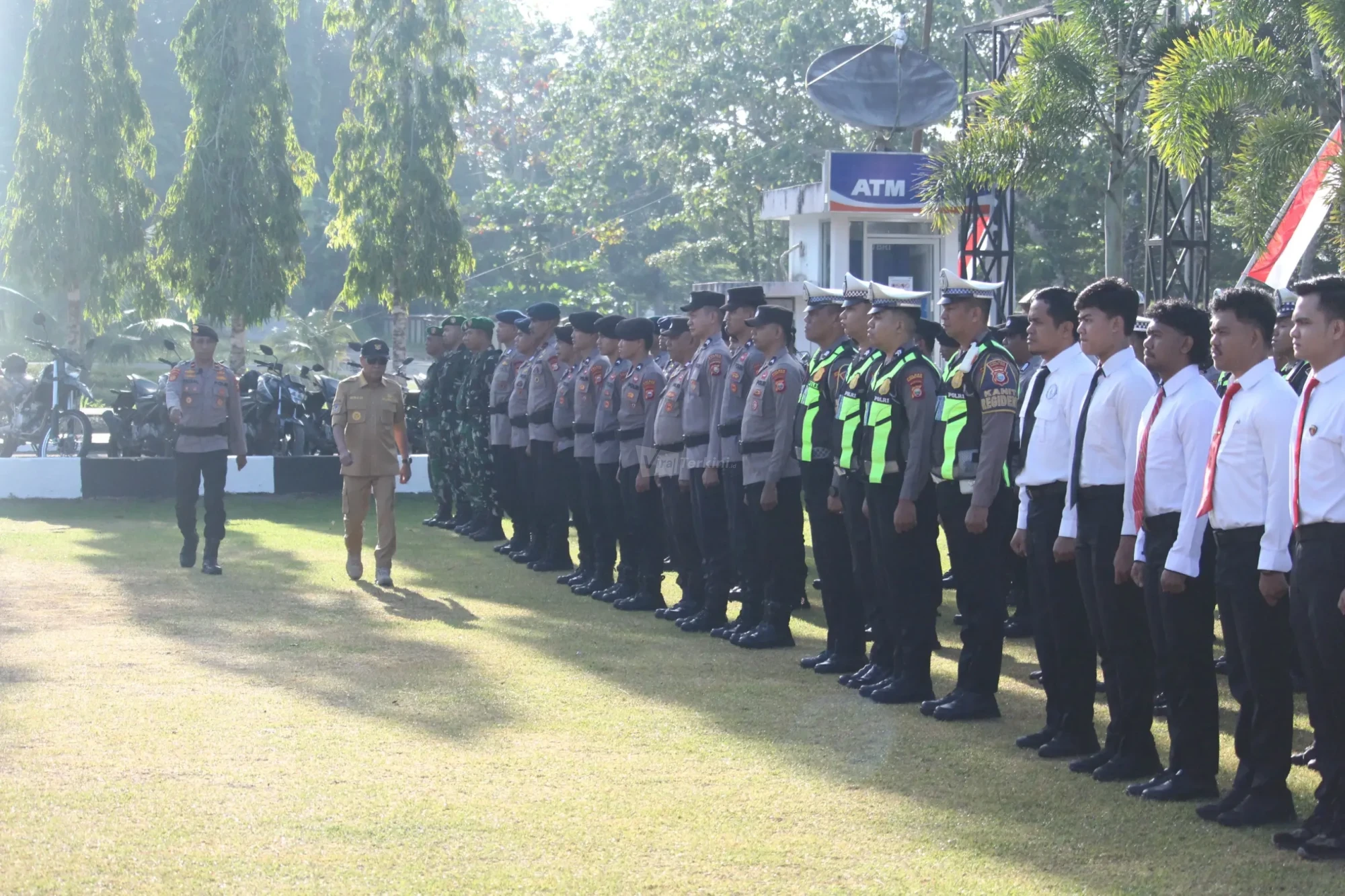 Bupati Halmahera Tengah, Dr. Ir. Ikram Malan Sangadji, M.Si., didampingi salah satu anggota Polri, berjalan melakukan pengecekan barisan personel gabungan TNI, Polri, dan unsur terkait saat memimpin Apel Siaga Pencegahan Karhutla di Mako Polres Halteng, Weda, (3/8/2026). Foto: ist