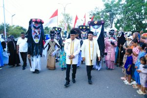Bupati Halteng Dr. Ir. Ikram Malan Sangadji, M.Si., dan Wakil Bupati Ahlan Djumadil S.IP., berjalan bersama para peserta bertopeng Cogoipa pada penutupan Fest Cogoipa 2026 di Weda, Halteng, Rabu (26/8/2026). (Foto: Dok. Pemda Halteng/Kokon)